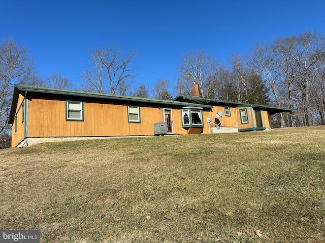 view of front of home featuring central AC and a front lawn