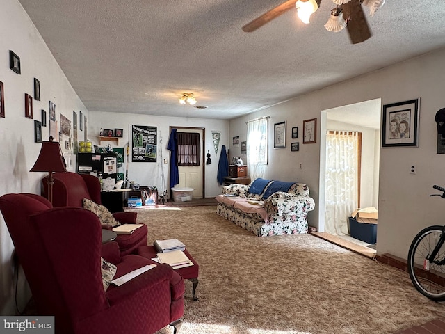 living room with ceiling fan, carpet, and a textured ceiling