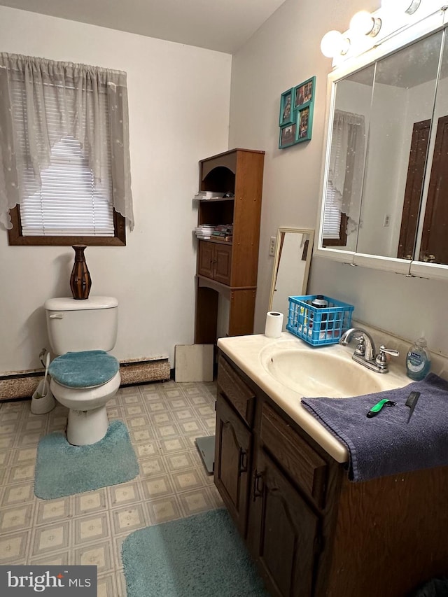 bathroom with tile flooring, vanity with extensive cabinet space, and toilet