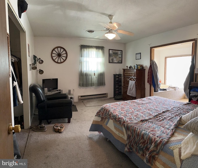 bedroom with ceiling fan, baseboard heating, and light carpet