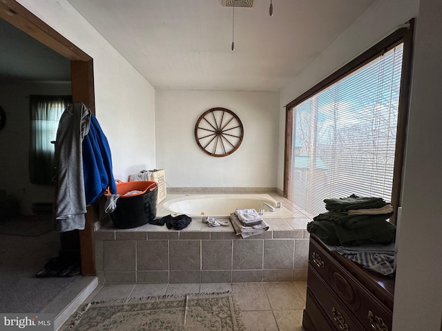 bathroom with tile floors and a relaxing tiled bath