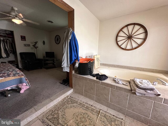 bathroom featuring ceiling fan, tile floors, and tiled tub