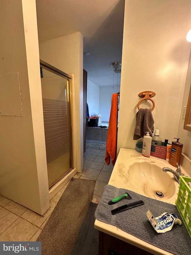 bathroom with tile floors, an enclosed shower, and vanity