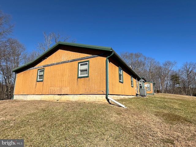 view of side of home featuring a lawn and central air condition unit