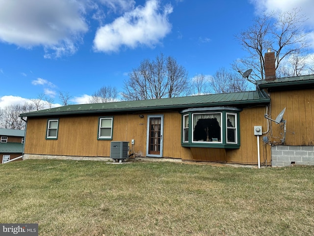 rear view of property with a lawn and central air condition unit