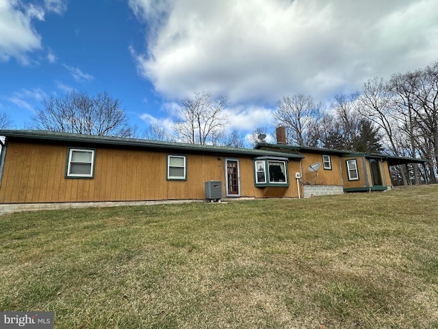 view of front of house featuring central AC and a front lawn