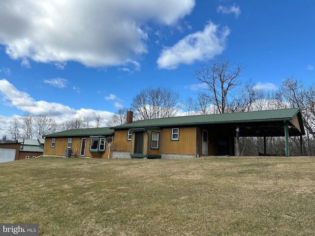 back of house with a lawn and a carport