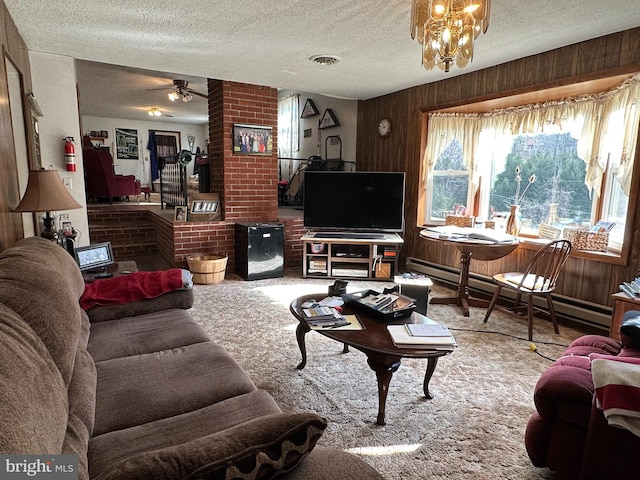 living room with carpet flooring, a textured ceiling, and ceiling fan with notable chandelier