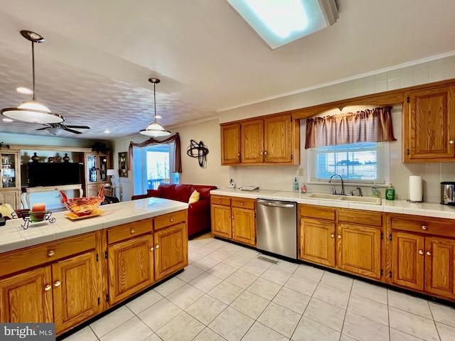 kitchen featuring ceiling fan, sink, stainless steel dishwasher, crown molding, and pendant lighting