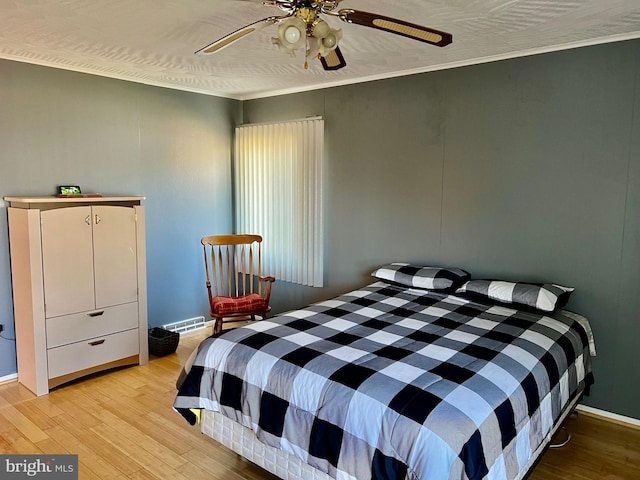 bedroom featuring ornamental molding, ceiling fan, and light hardwood / wood-style flooring