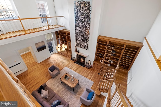 living room featuring light hardwood / wood-style floors, a high ceiling, and a chandelier