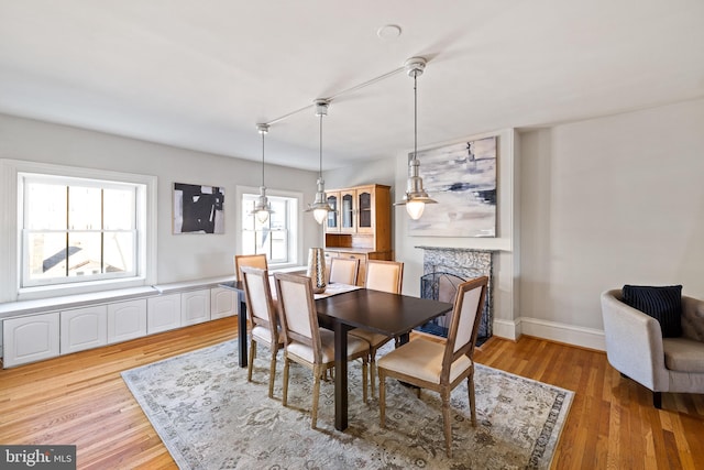 dining space with light hardwood / wood-style floors and a healthy amount of sunlight