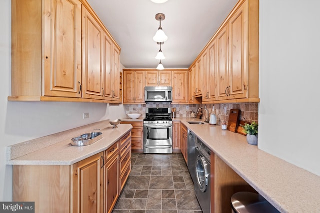 kitchen with stainless steel appliances, decorative light fixtures, tasteful backsplash, dark tile floors, and sink