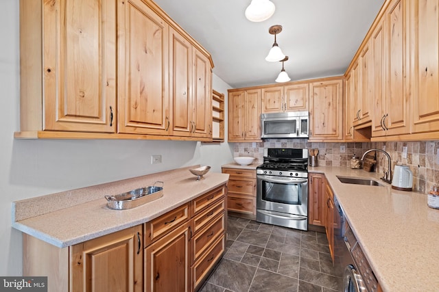 kitchen with hanging light fixtures, backsplash, appliances with stainless steel finishes, dark tile floors, and sink