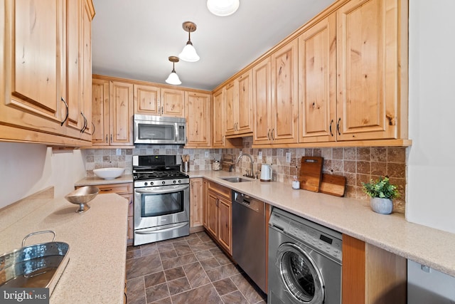 kitchen featuring backsplash, dark tile floors, stainless steel appliances, and washer / clothes dryer