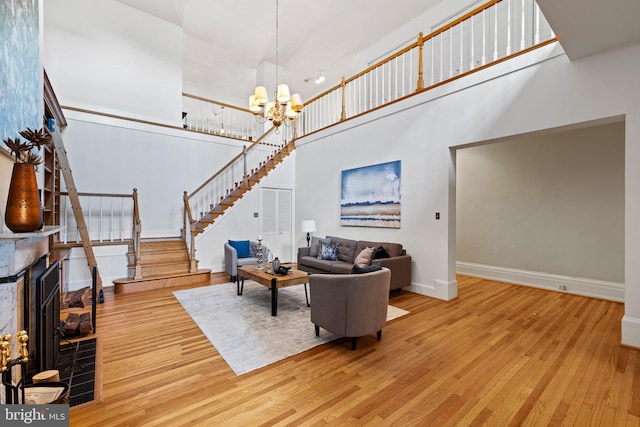 living room with a chandelier, a high ceiling, and light wood-type flooring