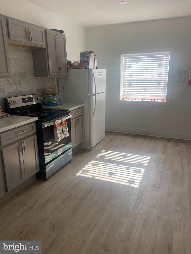 kitchen with gray cabinetry, stainless steel electric range oven, and light wood-type flooring