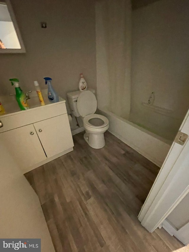 full bathroom with vanity, toilet, wood-type flooring, and shower / tub combo