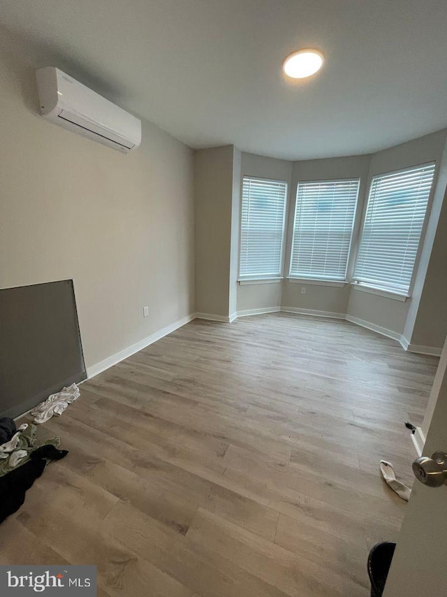 interior space with hardwood / wood-style floors and a wall unit AC