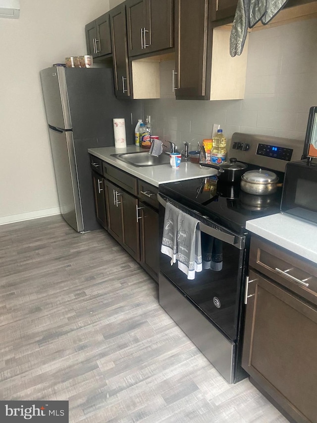 kitchen featuring electric stove, light hardwood / wood-style flooring, and dark brown cabinetry