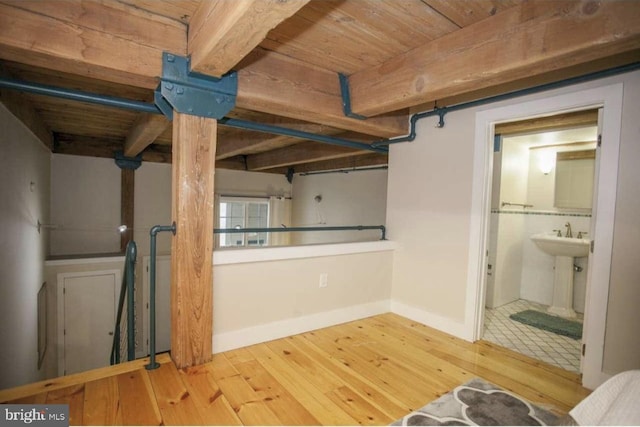 basement featuring light hardwood / wood-style floors and wooden ceiling