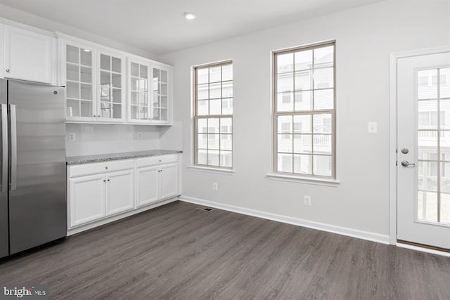 kitchen with white cabinetry, stainless steel refrigerator, and plenty of natural light