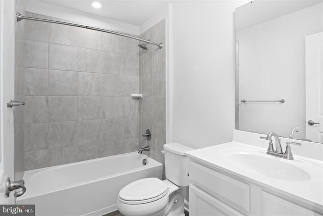 full bathroom featuring toilet, tiled shower / bath, and vanity