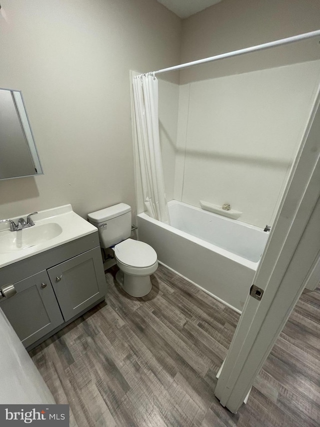 full bathroom featuring hardwood / wood-style floors, vanity, toilet, and shower / bath combination with curtain