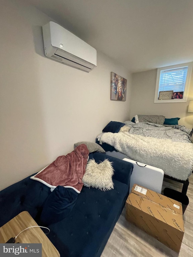 bedroom featuring light hardwood / wood-style flooring and a wall unit AC