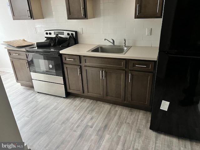 kitchen featuring dark brown cabinets, light hardwood / wood-style flooring, black fridge, electric range, and sink