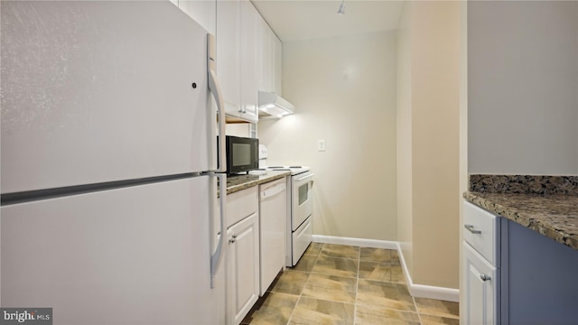 kitchen featuring white cabinets, light tile floors, stone countertops, and white appliances