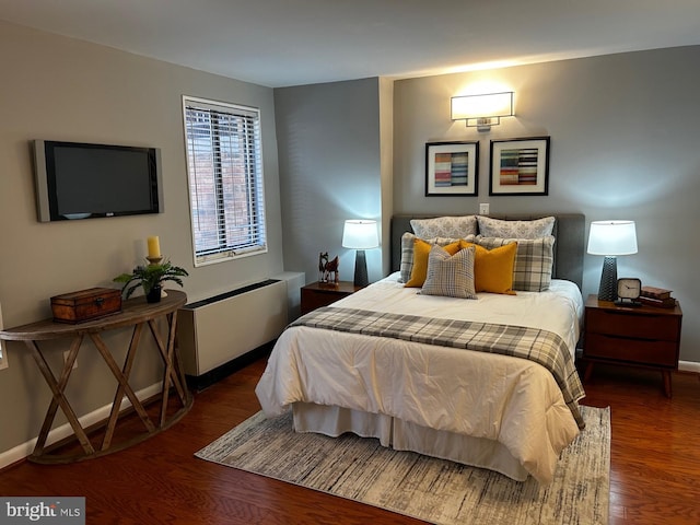 bedroom with radiator heating unit and dark wood-type flooring