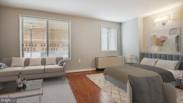 bedroom with radiator and hardwood / wood-style flooring