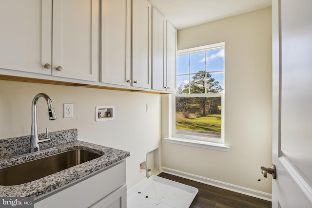 kitchen featuring white cabinets, sink, light stone counters, and dark hardwood / wood-style flooring