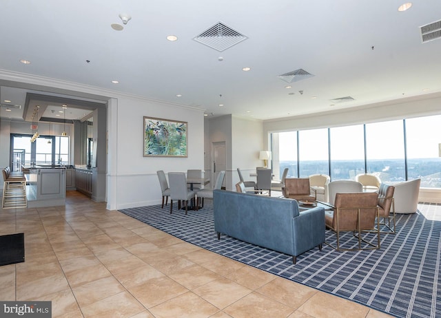 tiled living room featuring ornamental molding and a water view