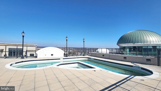 view of swimming pool featuring a patio and an in ground hot tub