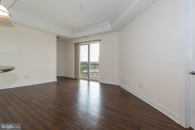 spare room featuring dark hardwood / wood-style floors and a tray ceiling