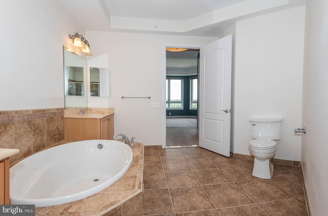 bathroom with tile flooring, vanity, toilet, and tiled bath