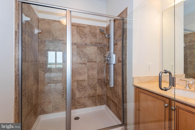 bathroom featuring vanity and a shower with door