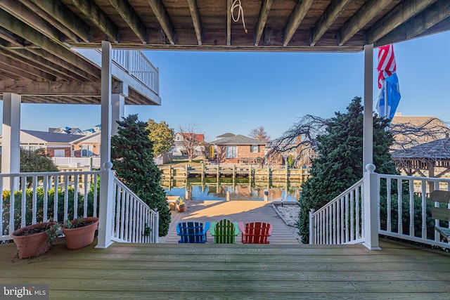 wooden deck featuring a water view and a boat dock