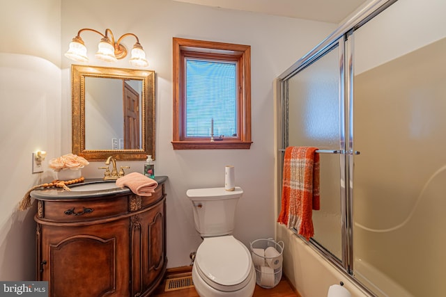 full bathroom with shower / bath combination with glass door, toilet, and vanity