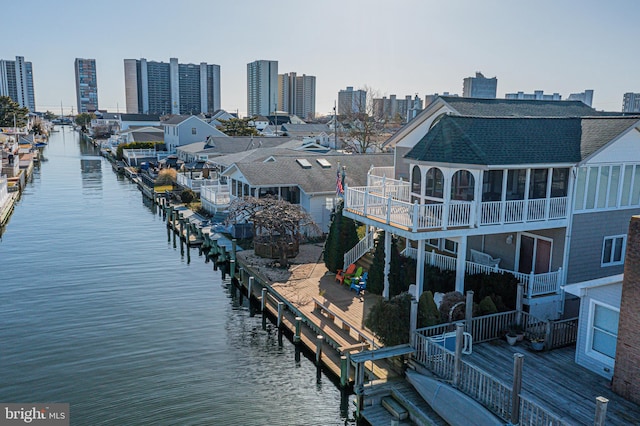 view of dock with a balcony and a water view