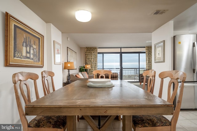 dining area featuring light tile flooring and a wall of windows