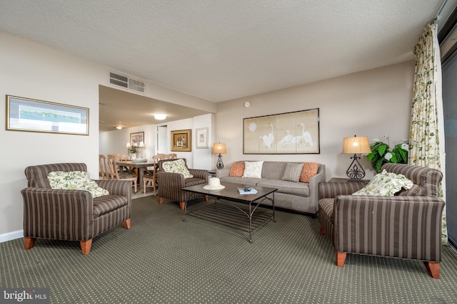 living room featuring a textured ceiling and dark colored carpet