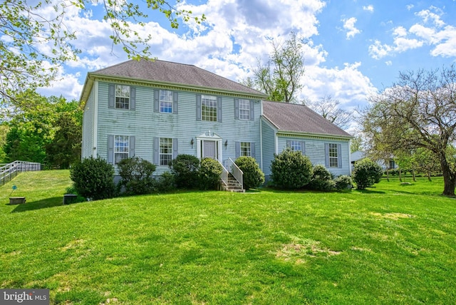 colonial-style house featuring a front lawn