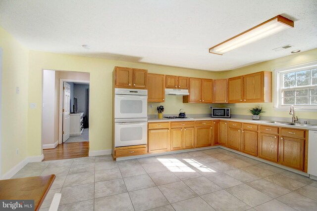 kitchen featuring appliances with stainless steel finishes, light tile floors, and sink