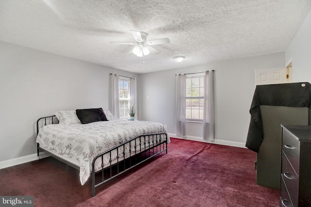 carpeted bedroom with ceiling fan and a textured ceiling