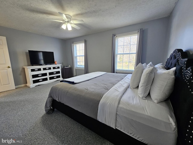 bedroom featuring ceiling fan, dark colored carpet, and a textured ceiling