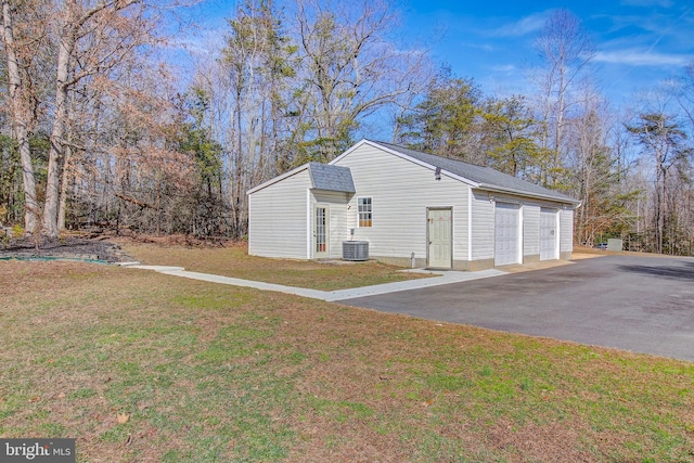 view of front of property with a front yard, central AC, and a garage