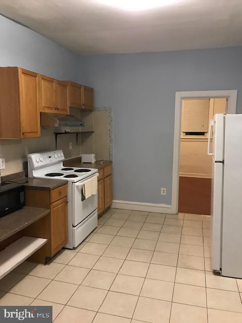 kitchen featuring white appliances and light tile floors